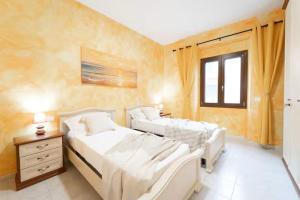 a bedroom with two beds and a window at Bidderosa in Orosei
