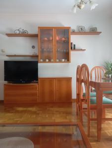 a living room with a television and a dining room table at Casa Chus in Foz