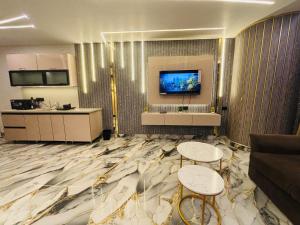 a living room with two tables and a flat screen tv at Nior luxury stays in Ghaziabad