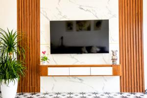 a living room with a television on a stone wall at Sweet Apartment Sa Pa in Sapa