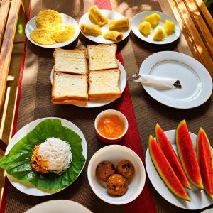 a table with plates of food on a table at Nature Lounge in Udawalawe