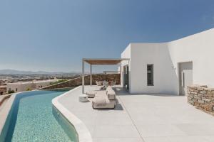 a villa with a swimming pool and a patio at Melora Villas Paros in Aliki