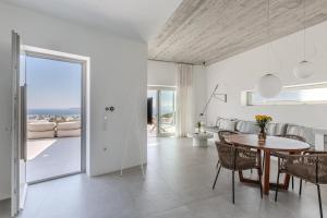 a dining room and living room with a table and chairs at Melora Villas Paros in Aliki