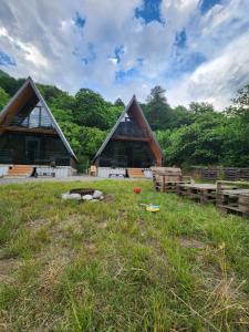 a building with two peaked roofs in the grass at Machakhela Peaks in Sindietʼi