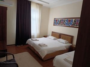a hotel room with two beds and a window at Green house eco hotel Samarkand in Samarkand