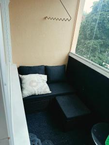 a small couch in a room with a window at Kotikolo in Pori +1 photo