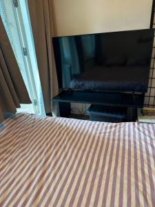 a bedroom with a bed and a flat screen tv at Kotikolo in Pori