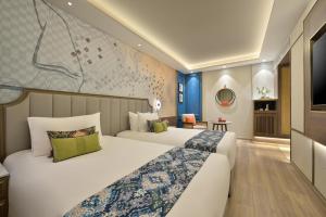 a hotel room with two beds and a tv at Boulevard9, Nadiad - IHCL SeleQtions in Nadiād