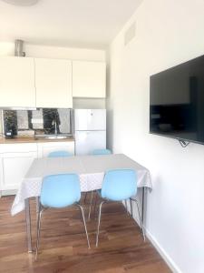 a kitchen with a table and three blue chairs at Arcimboldo 1 apartment in San Canzian dʼlsonzo +7 photos