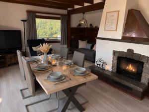 a dining room with a table and a fireplace at Ferienhaus Sonnendeck in Simmerath