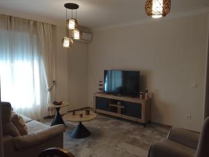 a living room with a couch and a flat screen tv at Piso de 3 habitaciones en el centro de Punta Umbria recién renovado! in Punta Umbría