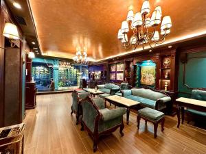 a bar with green chairs and tables and a chandelier at Tulip Hotel 2 in Da Lat