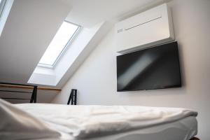 a flat screen tv hanging on a wall next to a bed at CASTLE apartments Premium - City Center in Spišské Podhradie