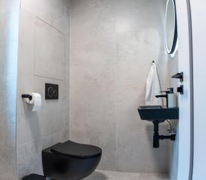 a bathroom with a black toilet and a sink at CASTLE apartments Premium - City Center in Spišské Podhradie +26 photos