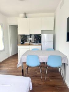 a kitchen with a table and blue chairs at Arcimboldo 2 apartment in San Canzian dʼlsonzo