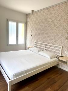 a white bed in a bedroom with a wall at Arcimboldo 2 apartment in San Canzian dʼlsonzo