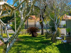 a yard with trees in front of a fence at 2BR Retro Luxe Family Hideaway in Gold Coast