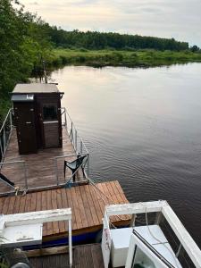 a wooden dock with a small shack on the water at Parvmaja Scarlett in Yyyezu