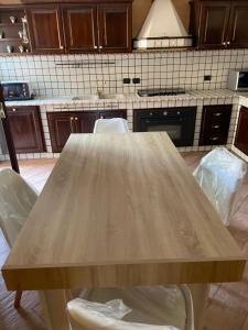 a wooden table in a kitchen with two chairs at la Dimora del centro di zafferana in Zafferana Etnea