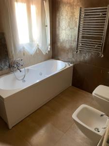 a bathroom with a tub and a toilet and a sink at la Dimora del centro di zafferana in Zafferana Etnea +3 photos