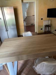 a large wooden table in a room with a kitchen at la Dimora del centro di zafferana in Zafferana Etnea