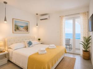 a bedroom with a bed with a view of the ocean at Villa Tamaris on the beach in Podstrana