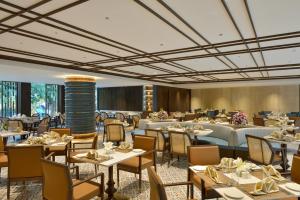 a restaurant with tables and chairs in a room at Boulevard9, Nadiad - IHCL SeleQtions in Nadiād