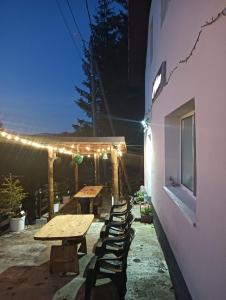 a group of tables and chairs on a patio at night at Acasă la Cutuca in Ranca