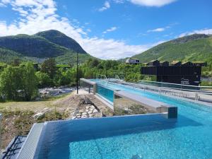 a large swimming pool with mountains in the background at Ramsbu utsikt terasse selvhushold in Hovden