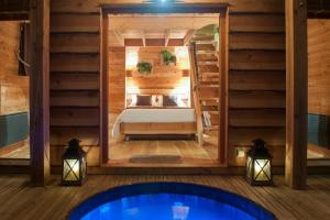 a bedroom in a log cabin with a bed and lights at Cabane du Bois des Nauzes in Seyches