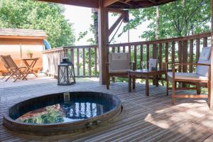 a patio with a fire pit on a deck at Cabane du Bois des Nauzes in Seyches +18 photos