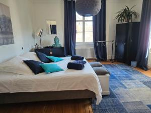 a bedroom with a large bed with blue pillows at Villa Amarinis in Saint-Amarin