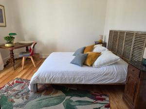 a bedroom with a bed with a wooden headboard and a table at Villa Amarinis in Saint-Amarin +3 photos