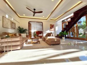 a living room with a couch and a ceiling fan at Three-Bedroom Luxury Garden Villa by Sing Siargao in General Luna