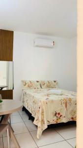 a bedroom with a bed with a floral bedspread at JACY AP GOSTOSO in São Miguel do Gostoso