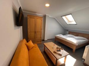 a living room with a couch and a bed at La SOFIIA in Săpânța