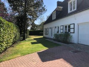 a white house with a garage and a driveway at Secret Garden in Waterloo