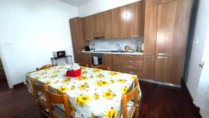 a kitchen with a table with sunflowers on it at Appartamento ROMANA in Lugo +8 photos