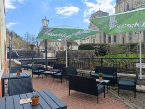 a patio with tables and chairs and a green umbrella at DIVA Studio in St. Blasien