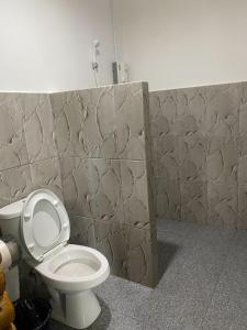 a bathroom with a toilet and a tile wall at PD RESORT Kohkood in Ko Kut