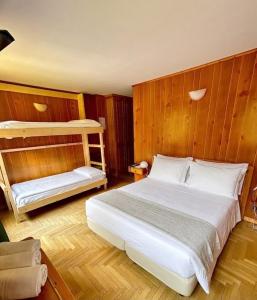 a bedroom with a white bed and bunk beds at Locanda del Lysjoch in Gressoney-la-Trinité
