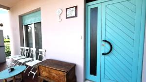a blue door on a porch with a table and chairs at Appartamento ROMANA in Lugo
