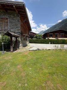 a house with a grass yard next to a building at Chalet d'Honneur in Chamonix