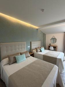 ein Hotelzimmer mit zwei Betten in einem Zimmer in der Unterkunft Hotel Marola in A Lanzada + 60 Fotos