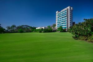 a large green field in front of a tall building at Boulevard9, Nadiad - IHCL SeleQtions in Nadiād