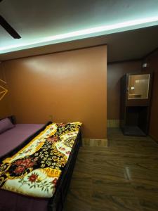 a bedroom with a bed in a room with a wall at Nahor Regency in Guwahati