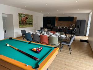a room with a pool table and a dining room at Gite du haras in Erbrée