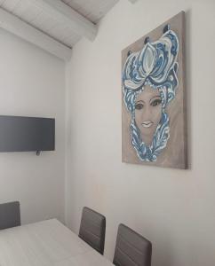a room with a table and a painting of a woman at Domus San Francesco in Castelvetrano Selinunte