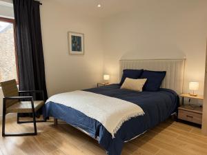 a bedroom with a bed and a chair and a window at Gite du haras in Erbrée