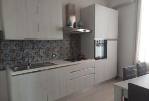 a kitchen with white cabinets and a sink at Domus San Francesco in Castelvetrano Selinunte